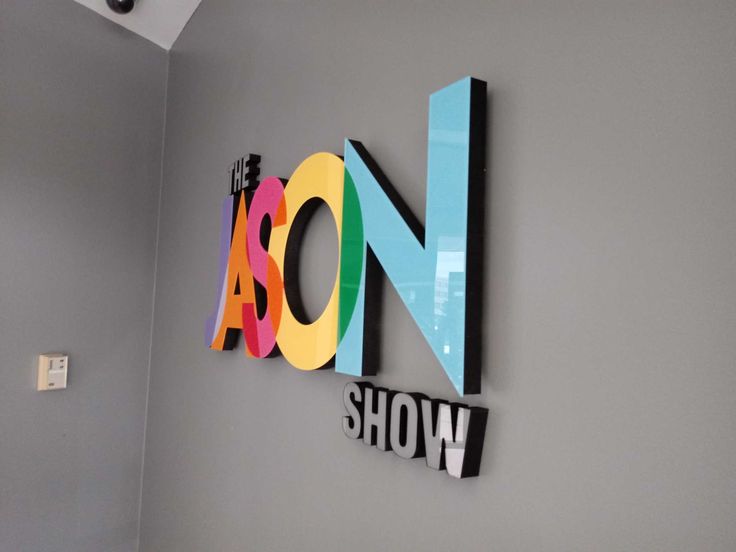 the noosa show sign is mounted on the wall in an office space with gray walls