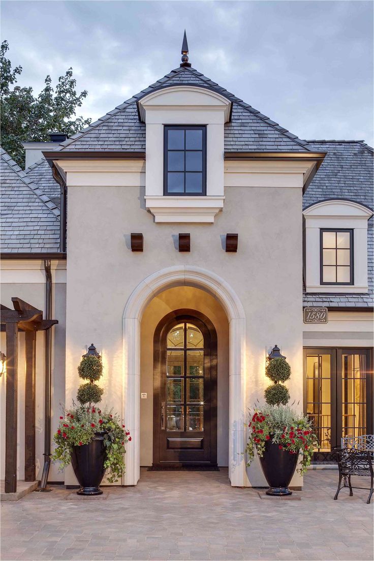 the front entrance of a house with potted plants