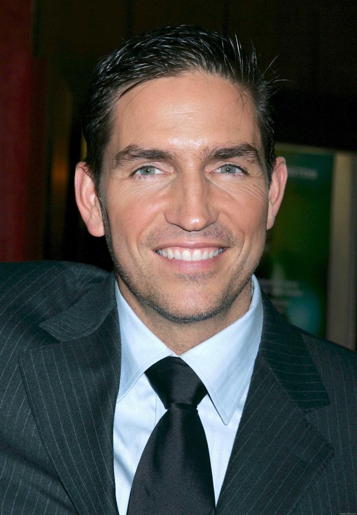 a man in a suit and tie smiling at the camera