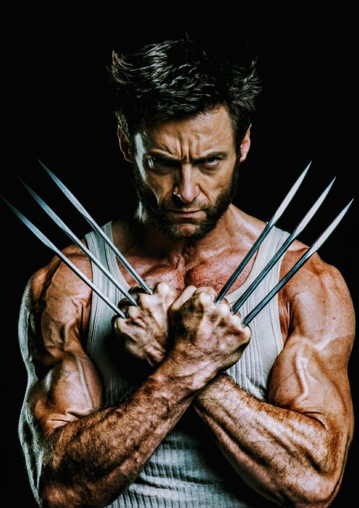 the wolverine man is posing with his hands crossed in front of his chest and muscles