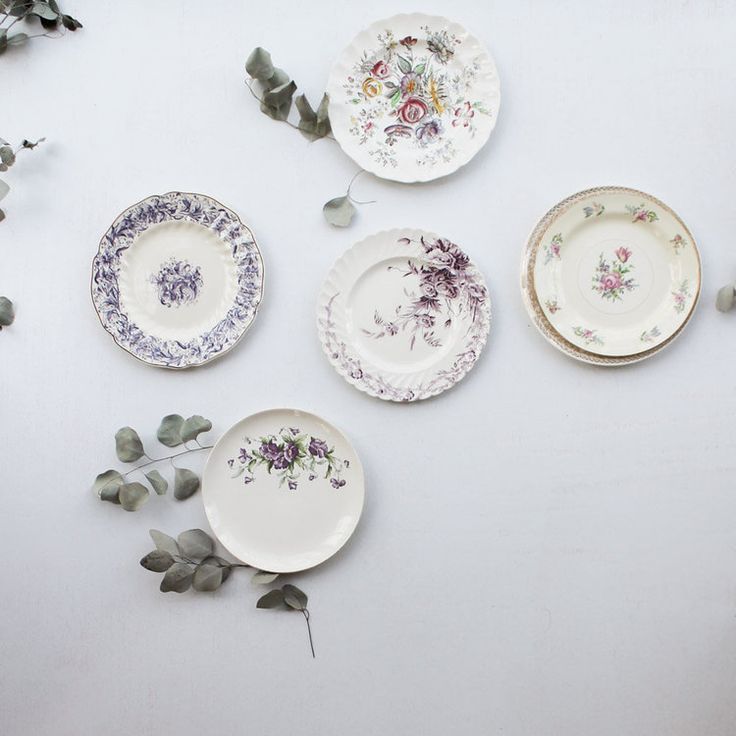 five plates with flowers and leaves on them are arranged in the shape of a circle