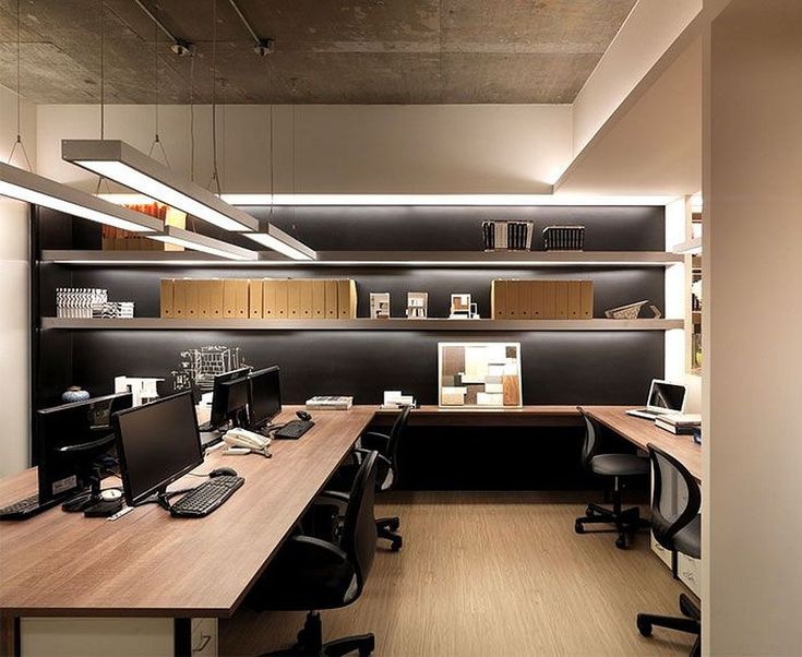 an office with two desks and several computers