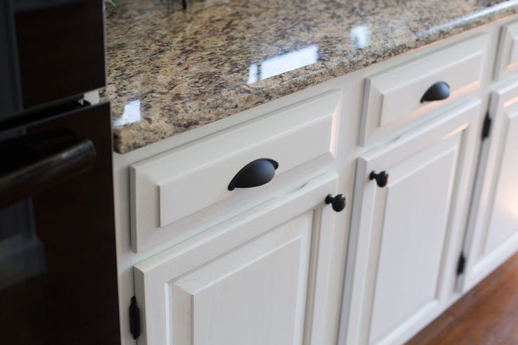 an image of a kitchen setting with granite counter tops and white cabinets in the background