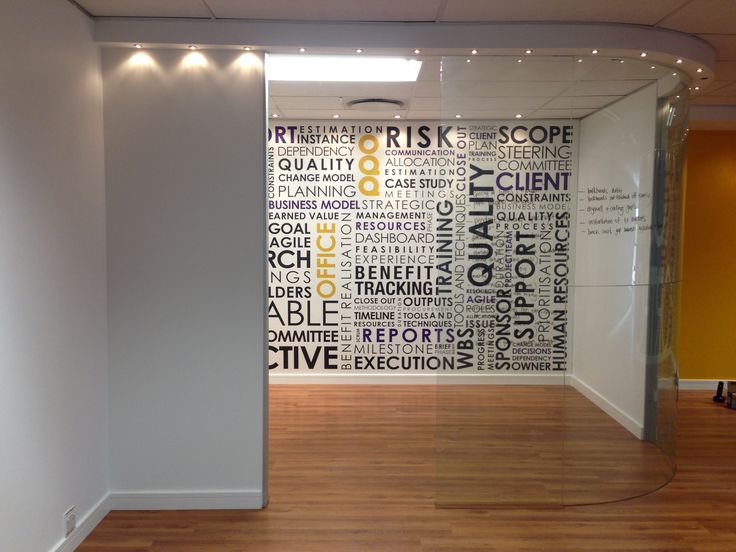 an empty room with wood floors and white walls, decorated with words on the wall