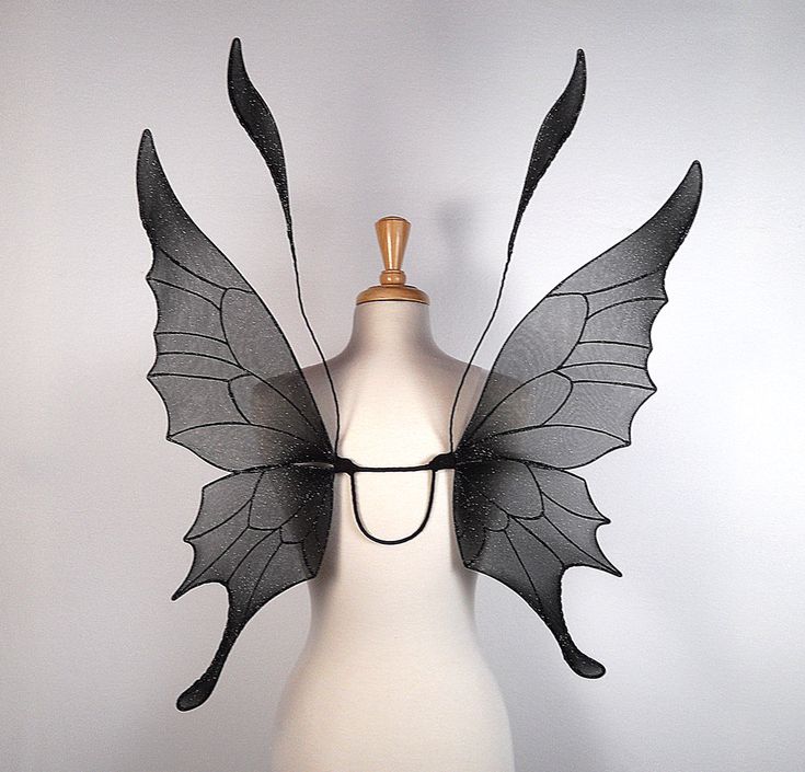 a white mannequin with black wings on it