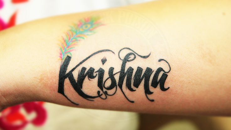 a person with a tattoo on their arm that says kirshna in cursive writing