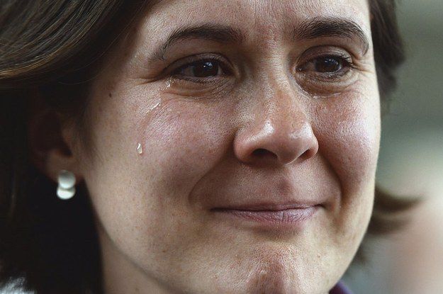 a close up of a person wearing a suit and tie with tears on her face