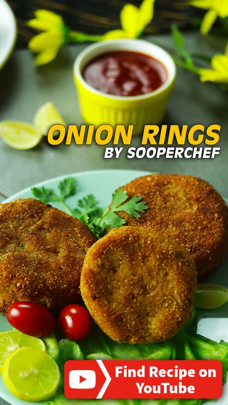 two fried fish patties on a plate with tomatoes and lettuce next to dipping sauce