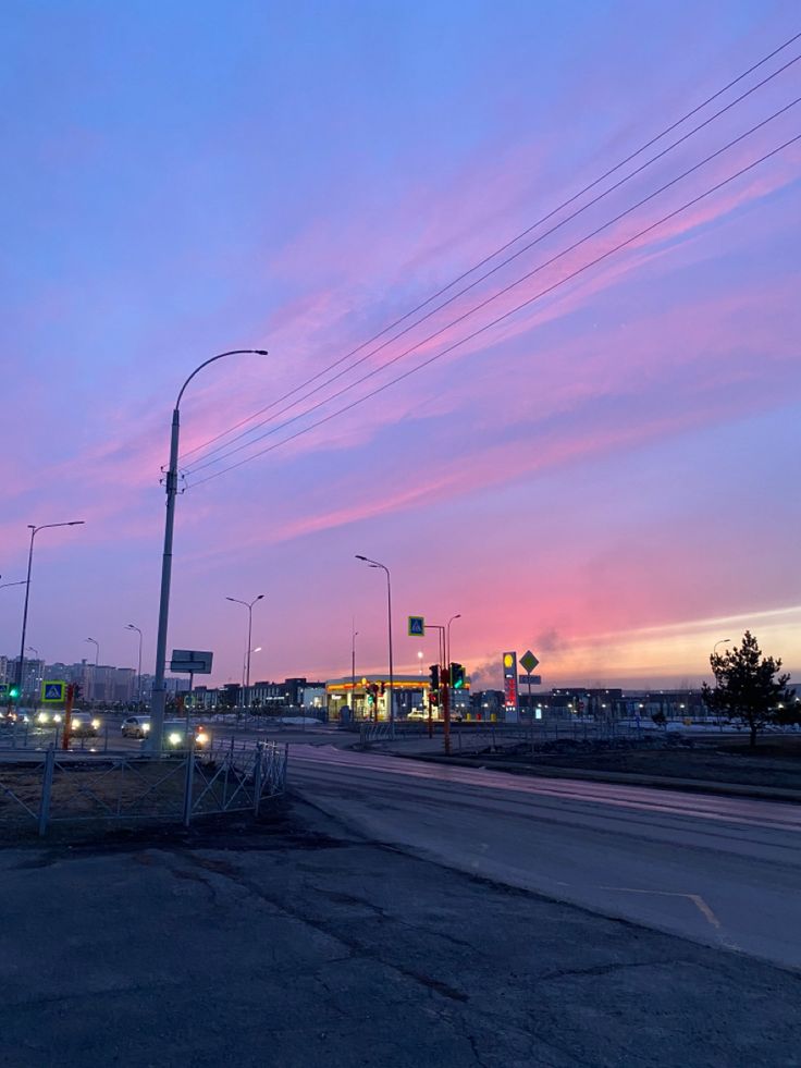 an empty street at dusk with traffic lights