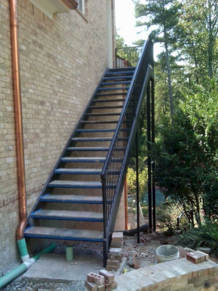 a set of stairs leading up to a brick building with trees in the back ground