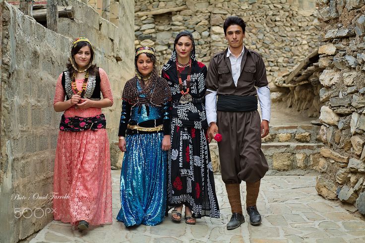 a group of people standing next to each other on a stone walkway in an old village