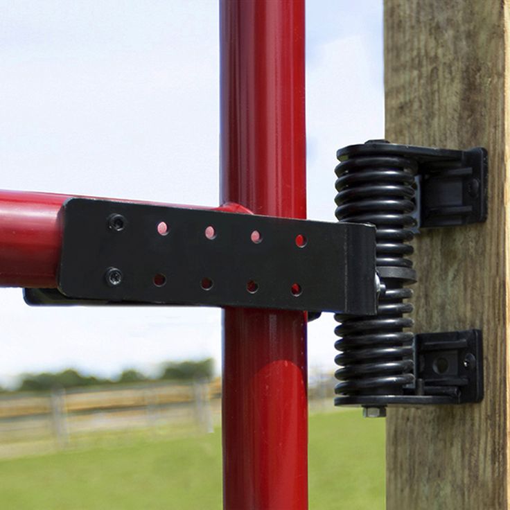 a close up of a red and black object on a wooden pole with a fence in the background