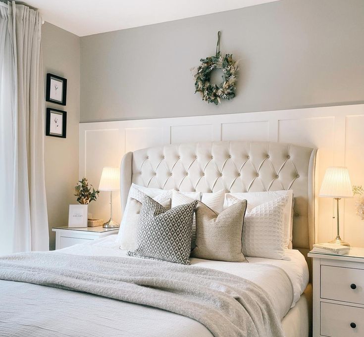 a white bed sitting in a bedroom next to two lamps on either side of it