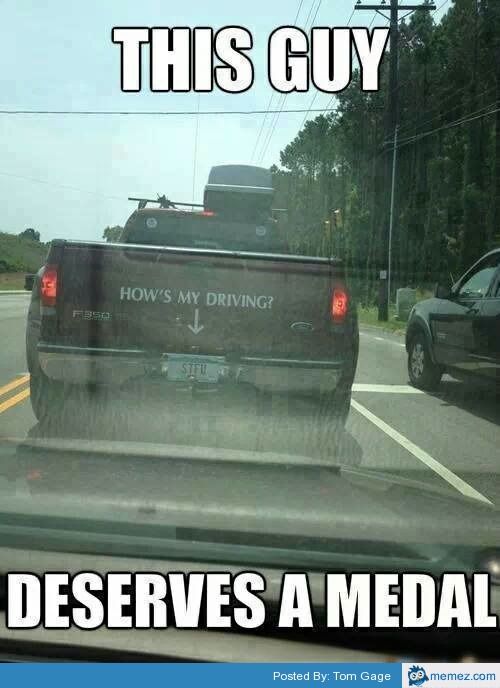 the back end of a pickup truck driving down a road with trees in the background that says, this guy deserves a medal