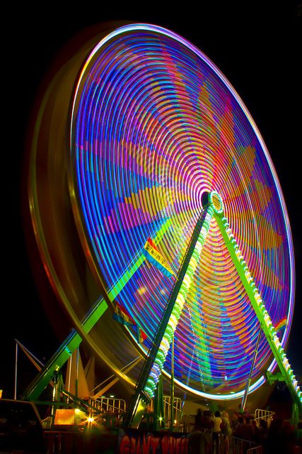 a ferris wheel at night with colorful lights