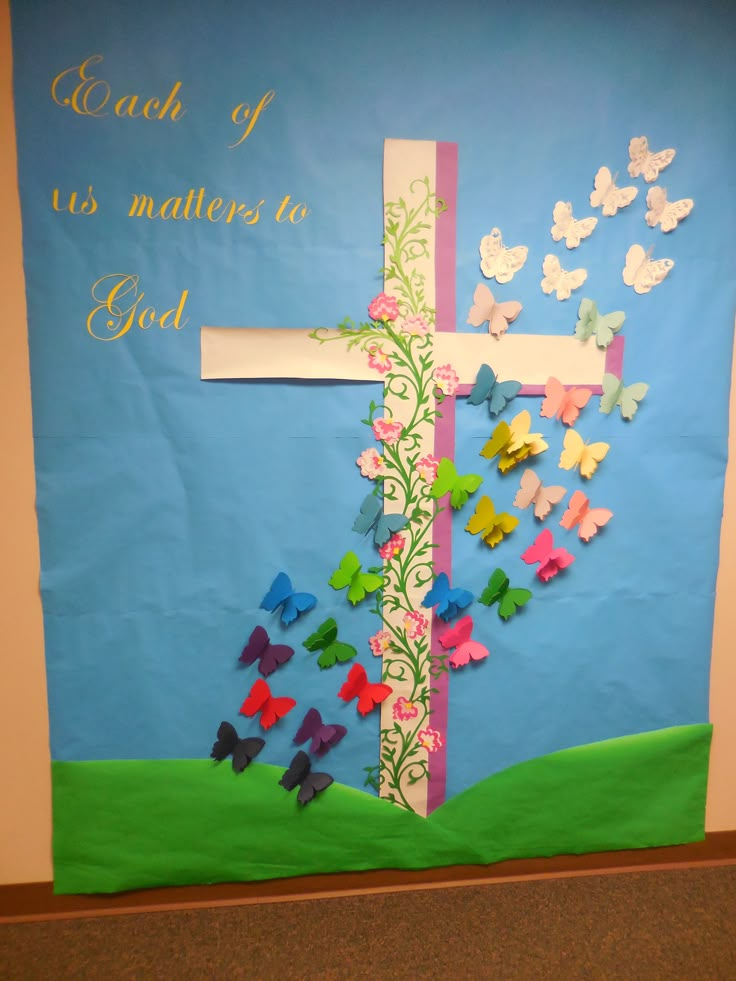 a bulletin board decorated with butterflies and a cross