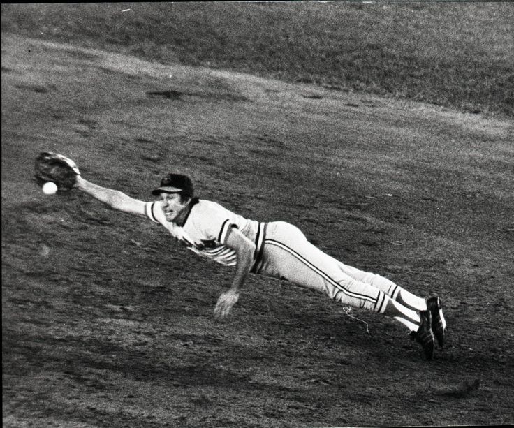 a baseball player diving to catch a ball