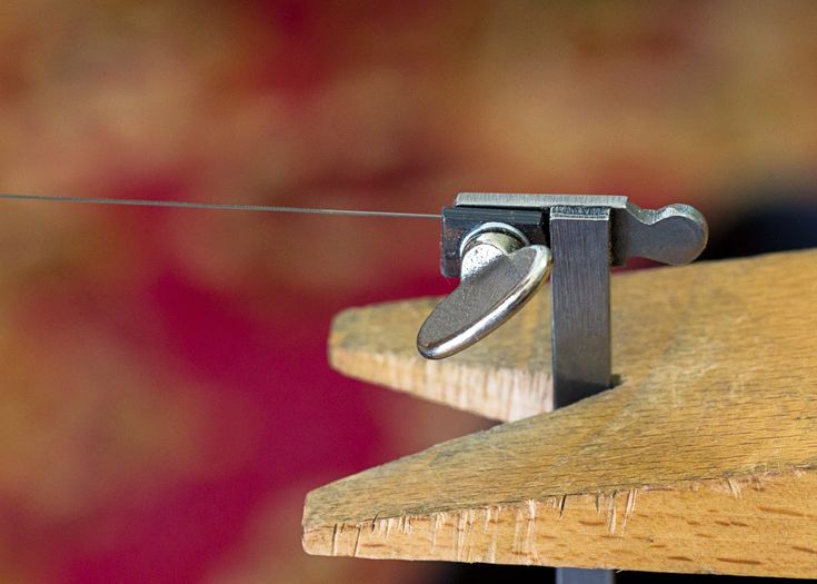 a close up of a wooden bench with a metal hook on it's end