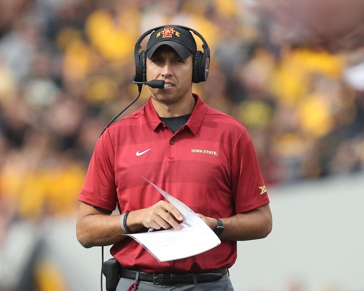 a close up of a football player wearing headphones and holding a piece of paper