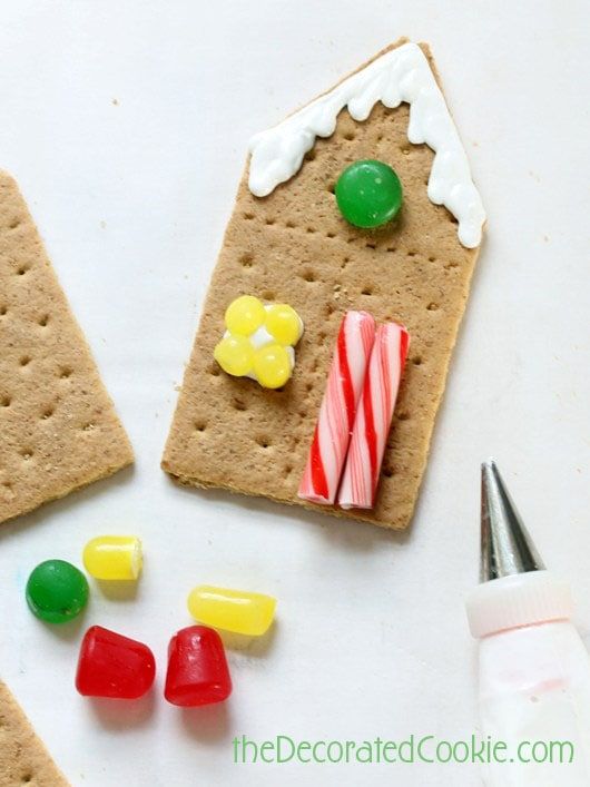 gingerbread crackers decorated with candy, candies and marshmallows on a white surface