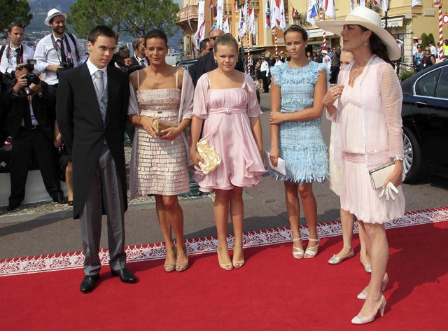 a group of people standing on top of a red carpet