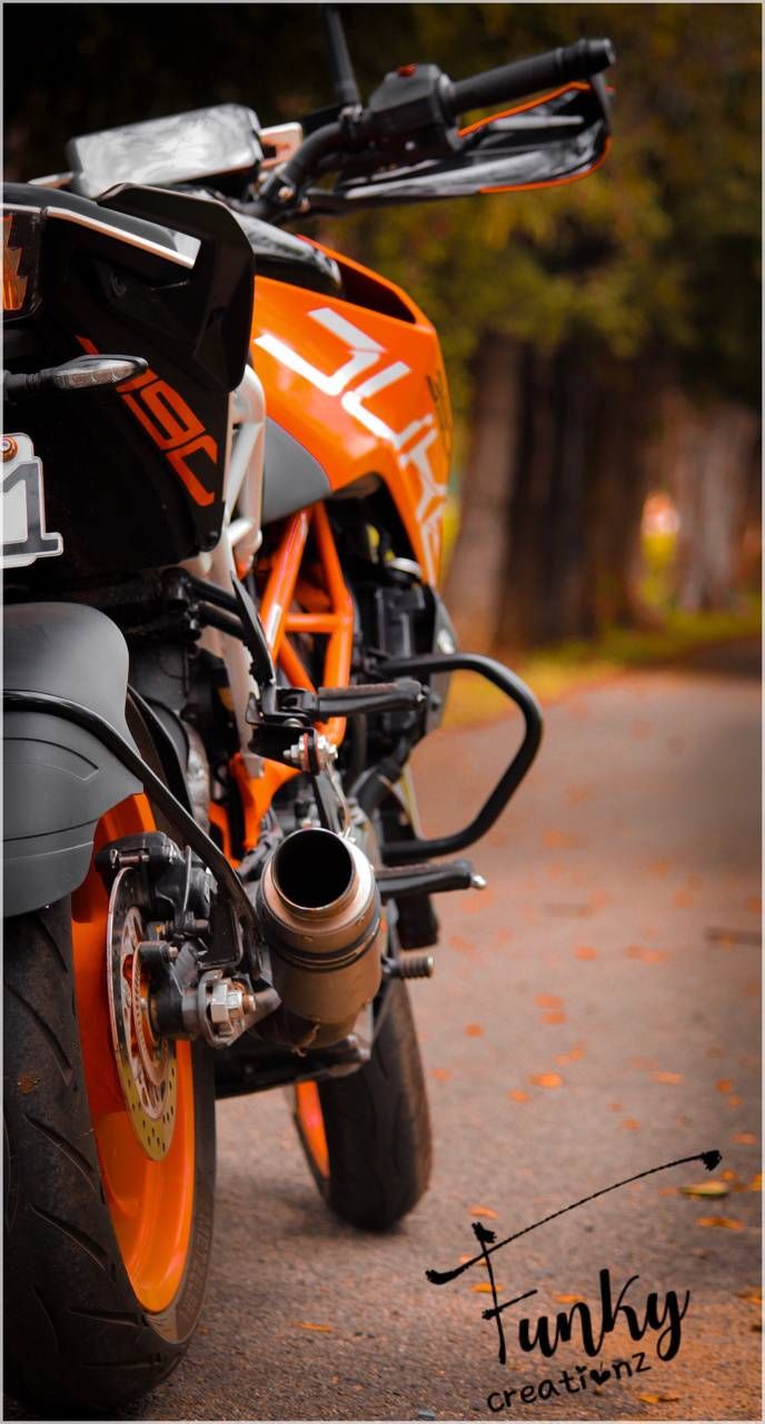 an orange and black motorcycle parked on the street