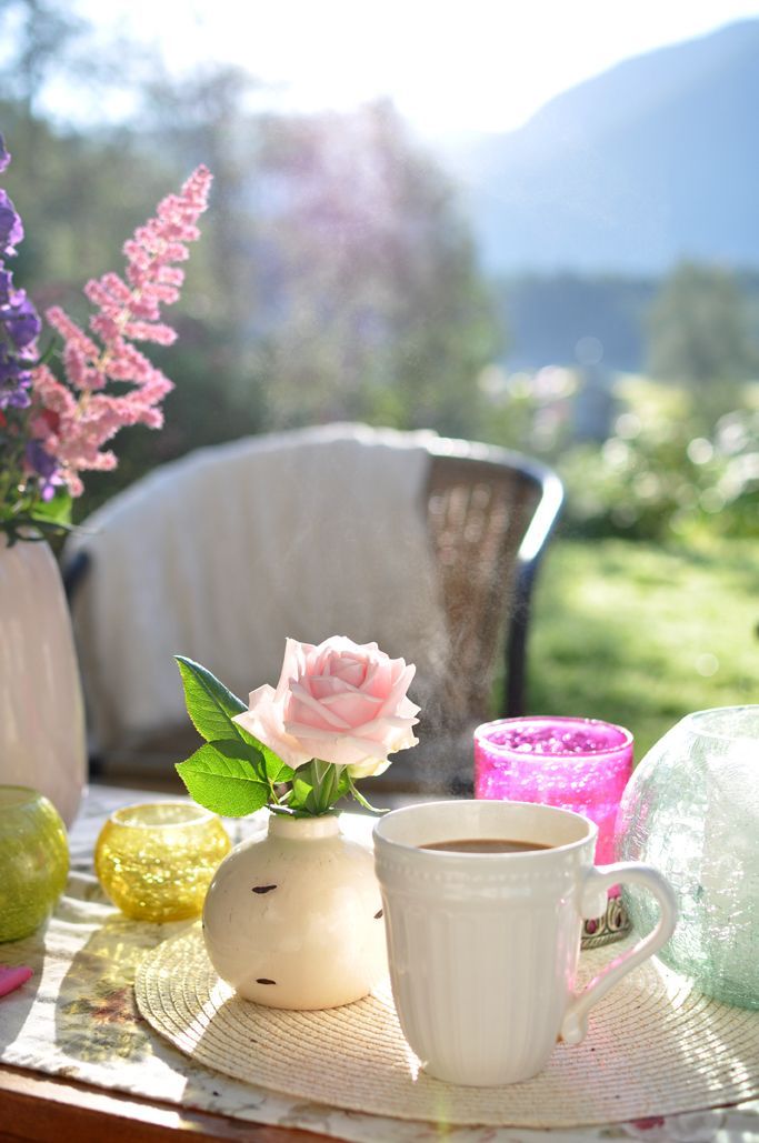 there are two cups on the table with pink flowers in them and one cup is empty