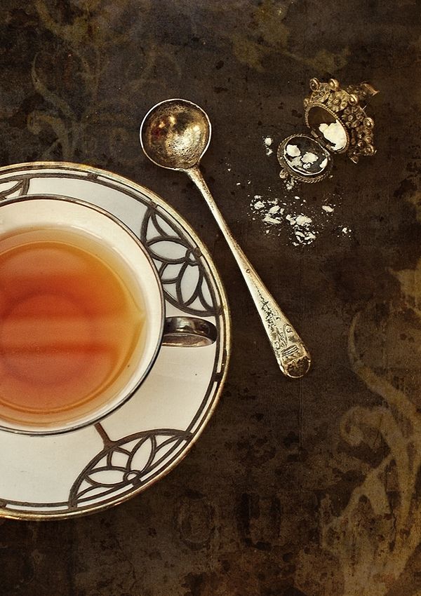 a cup of tea on a saucer and spoon