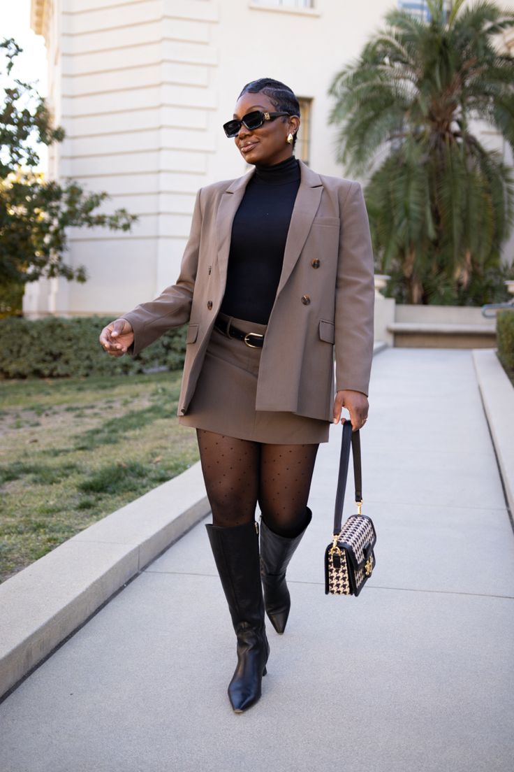 Black women with a short pixie cut wearing a taupe colored mini skirt suit with sheer tights, black knee high boots, houndstooth purse and black sunglasses Pencil Skirt Suit Outfit, Skirt Suit Black Women, Female Skirt Suits, Debate Outfits, Skirt Suit Outfit, Grad Suits, Winter Mini Skirt, Style A Skirt, Dress And Blazer Outfit