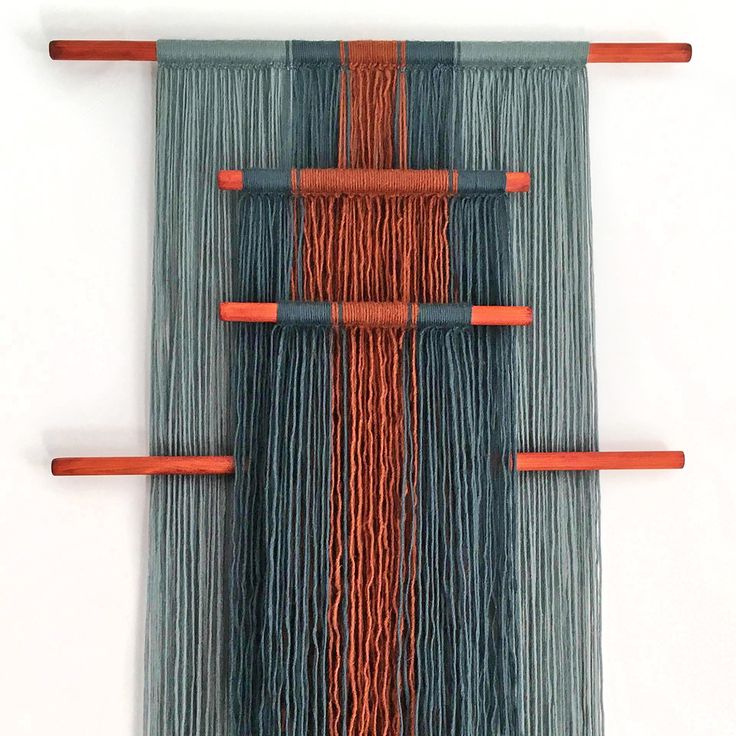 an orange and blue wall hanging on a white wall