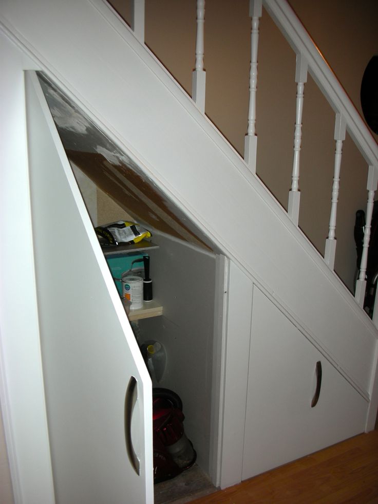 an open closet under the stairs in a house