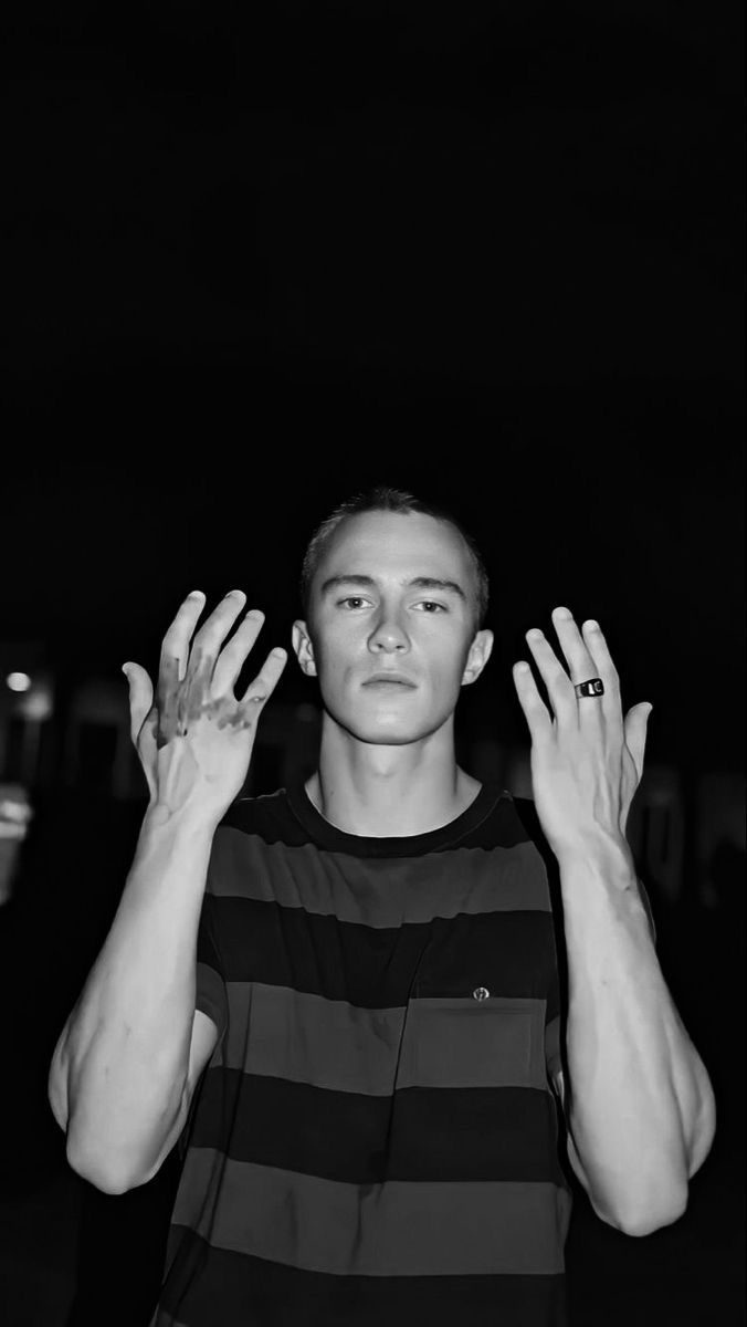 a young man is holding his hands up in the air