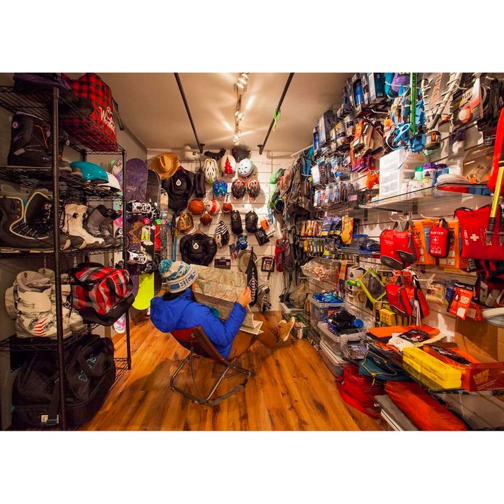 a room filled with lots of luggage and hats on shelves next to a wooden floor