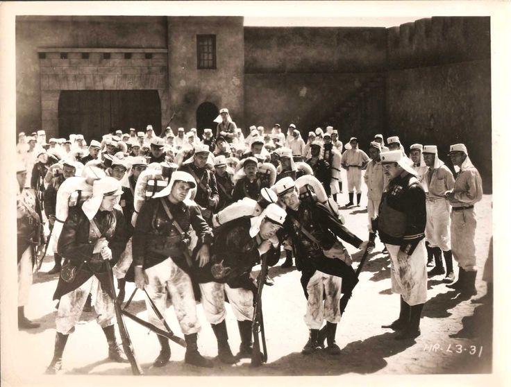 an old black and white photo of people standing in front of a building with their backs to the camera