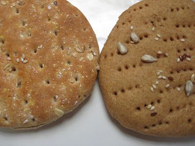 two cookies sitting on top of a white table next to each other, one with nuts