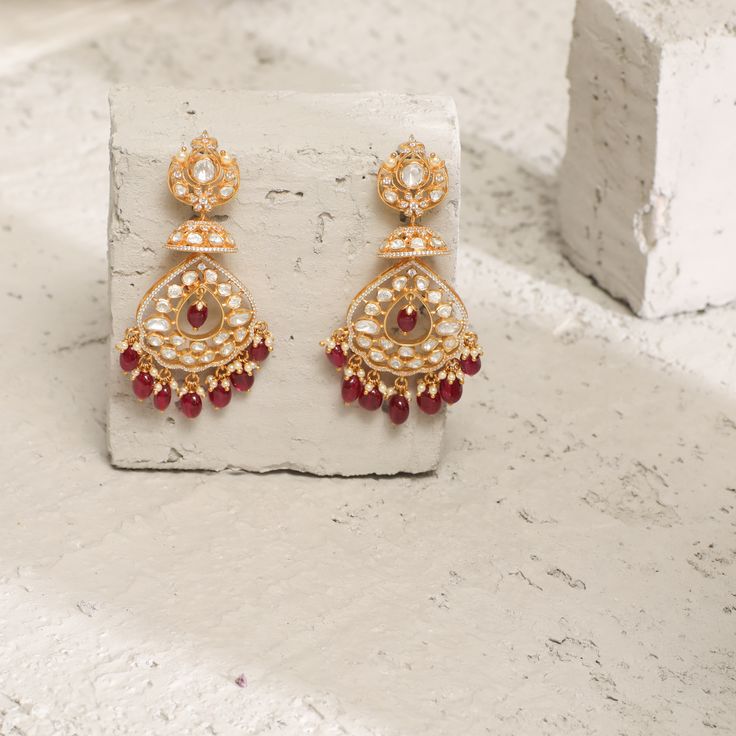 Description: Spark your traditional style with these regal silver dangle earrings from Paksha. Featuring a dazzling moissanite stone on the stud along with CZ intricate, layered with moissanite studded jhumki and chandbali layers. This pair is finished with gold-tone plating and little pearl & ruby bead drops. Wear yours with other moissanite jewelry – these are true favorites. Product Information Materials used: 925 Silver with 1.0-microns Yellow Gold Plating Stones: Semi precious stones Length Elegant Ruby Chandbali Danglers, Festive Ruby Chandbalis In Elegant Style, Elegant Festive Ruby Chandbalis, Festive Ruby Chandbalis, Hand Set Chandbali Diamond Earrings As Gift, Intricate Design Earrings For Festive Reception, Elegant Ruby Chandbali Bridal Earrings, Festive Cubic Zirconia Chandbalis, Festive Elegant Drop Danglers Earrings