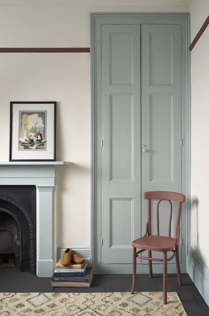 a room with a chair, fireplace and pictures on the wall