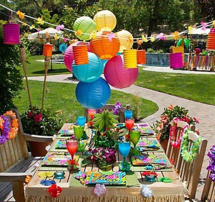 an outdoor table with colorful paper lanterns hanging from it