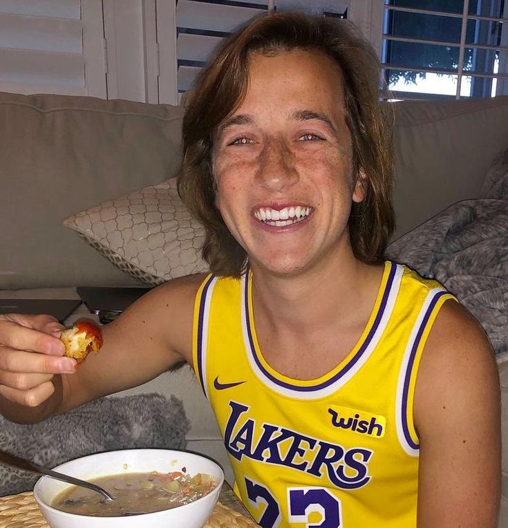 a woman in a yellow shirt is eating some food