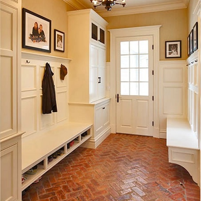 a hallway with brick flooring and white walls