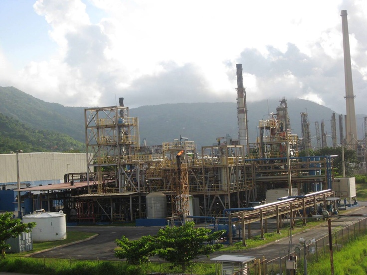 an industrial plant with mountains in the background