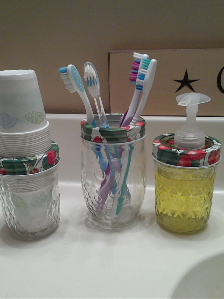 toothbrushes and cups are lined up on the counter