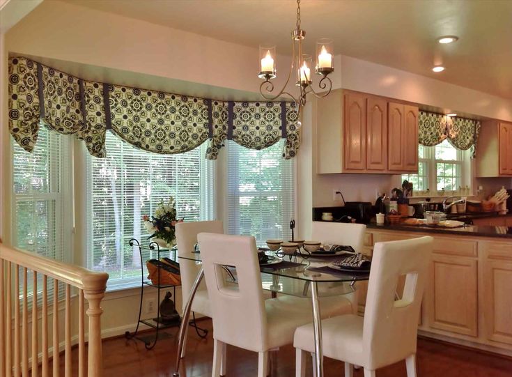 a dinning room table with four chairs in front of a kitchen counter and window