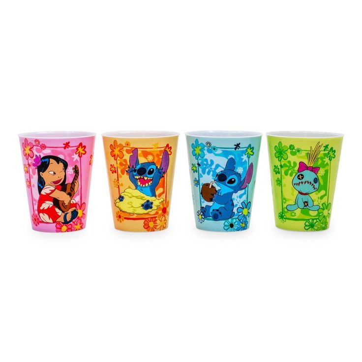 four different colored shot glasses with cartoon characters on the front and back, all lined up in a row