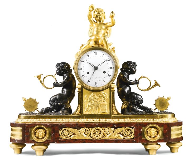 an ornate clock with two cherubs on it's sides and a gold finish