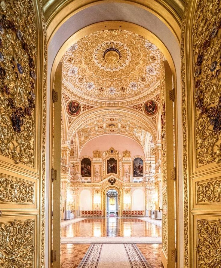 the inside of an ornately decorated building with gold and white decorations on the walls