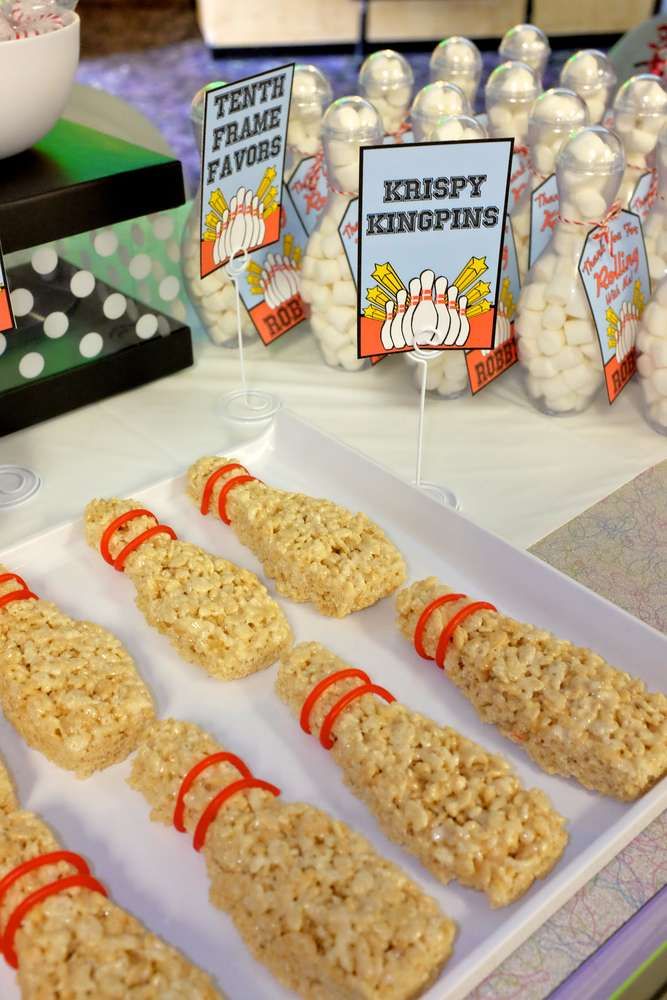 rice krispy kreme treats are displayed on a tray with candy sticks in front of them