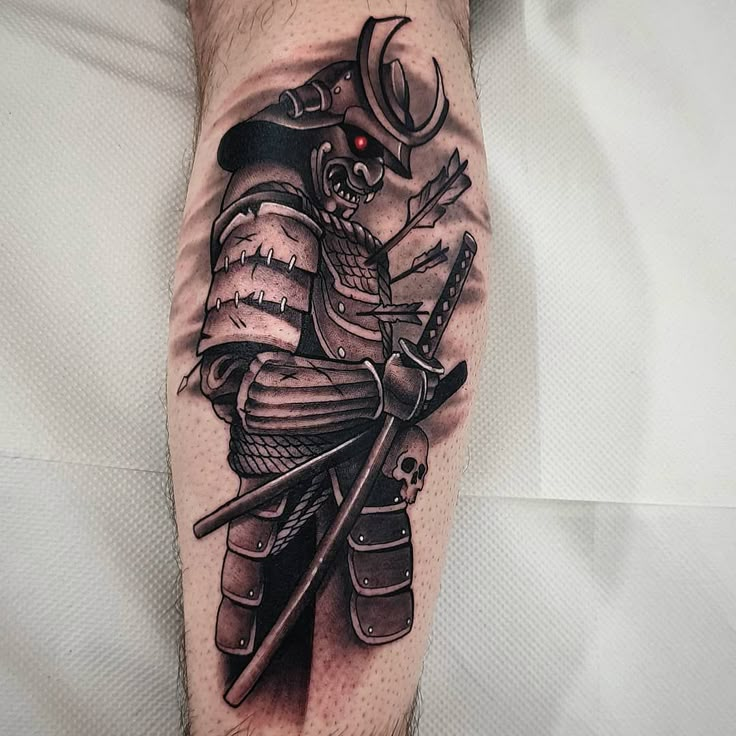 a man's leg with a tattoo on it that has an image of a samurai and two swords