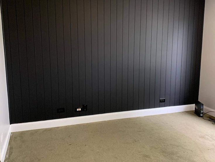 an empty room with black paneling on the walls