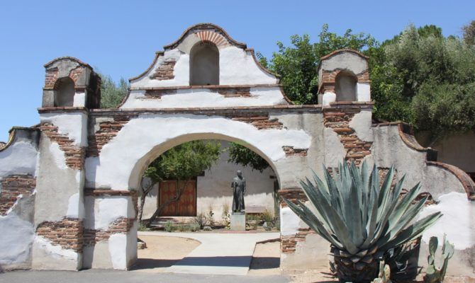 an old adobe building with a cactus in the foreground